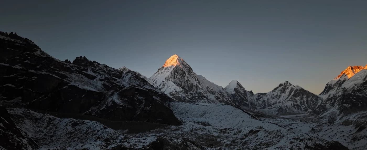 Starry night sky over snow-capped Himalayan mountain peaks along the Everest Base Camp trekking route.