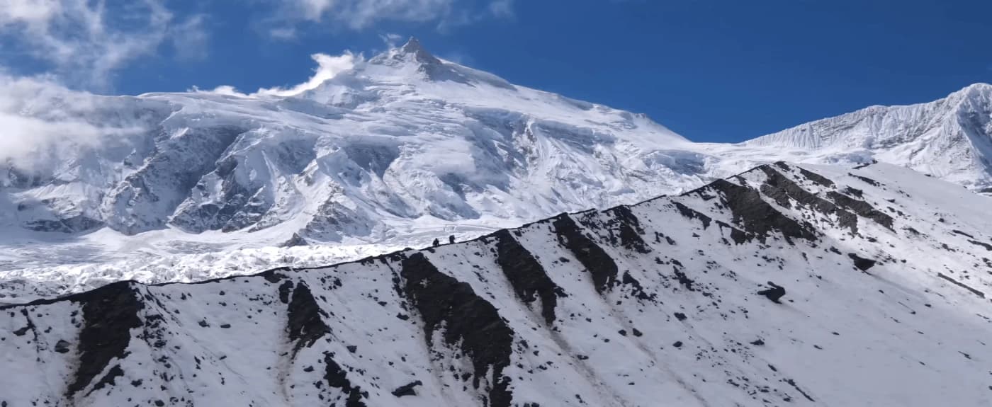 Mount Manaslu towering above trekkers on the Manaslu Circuit Trek in Nepal